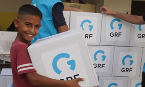 child smiling holding Lebanon aid parcel from Islamic charity GRF